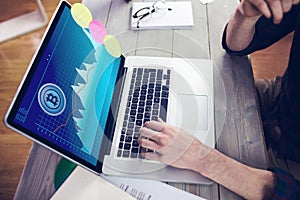 Hands of caucasian businessman sitting at desk, using laptop with statistical data on screen photo