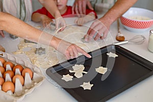 Hands of caucasian family baking together, making cookies in kitchen