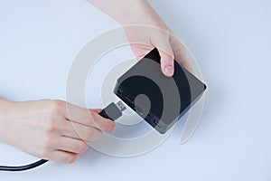 Hands of caucasian woman connects hdmi cable TV box  black box. White background