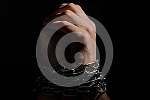 Hands are chained in chains isolated on black background