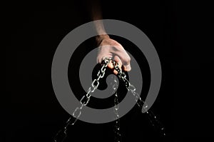 Hands are chained in chains isolated on black background