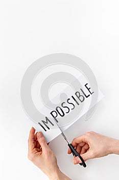 Hands changing word impossible to possible with scissors. Selfmade concept