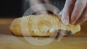 Hands of Chef Cuts Baguette Close Up