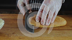Hands of Chef Cuts Baguette by Knife