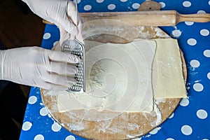 Hands of a chef grating cheese
