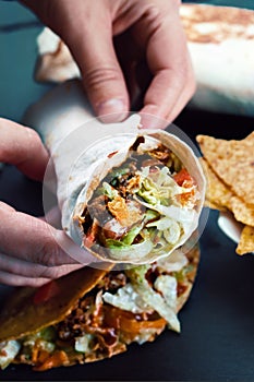 Hands of chef holding burrito