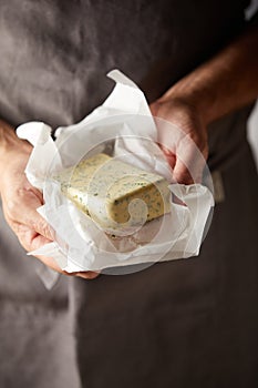 Hands of a chef holding a pat of farm fresh butter