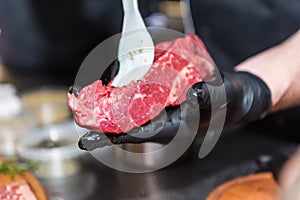 The hands of the chef lubricate raw meat