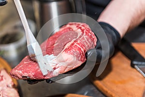 The hands of the chef lubricate raw meat