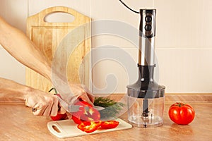 Hands chefs cut bell pepper on kitchen table