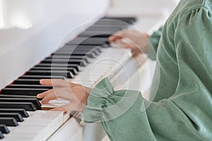 Hands of a child close-up playing the piano.