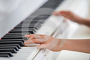 Hands of a child close-up playing the piano