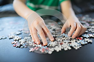 Hands of a child doing a puzzle