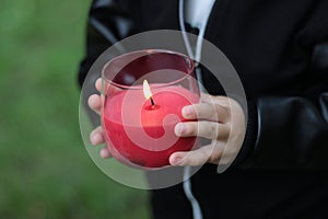 Hands of a child holding a candle, sign of hope concept