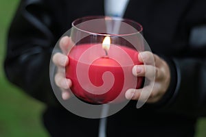 Hands of a child holding a candle, sign of hope concept