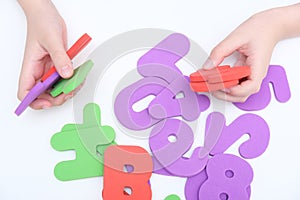 Hands of a child, kid holding colorful numbers during education, learning math