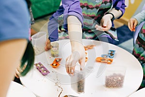 Hands of a child, a master class in cooking chocolate, folding fruit and chocolate into molds