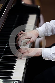 Hands of a child playing the piano