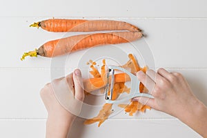 Hands of a child with a special knife for paring vegetables