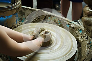 Hands of a child working the clay