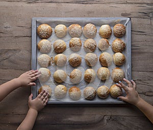 hands of children reaching for fresh baked buns