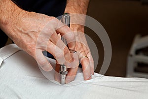 Hands of a Chiropractor Using an Integrator to Adjust the Spine