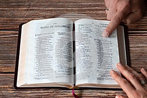 Hands of Christian couple holding Bible Book while reading together, song of Solomon, love concept