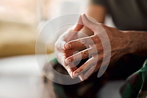 Hands clasped, soldier sitting and military person with anxiety, depression or problem on sofa. Army man, couch and ptsd