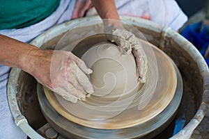 Hands in clay making a pot