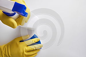 Hands of cleaning staff with cleaning tools on table top