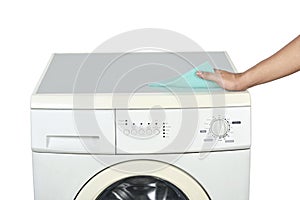 Hands cleaning the washing machine with a washcloth