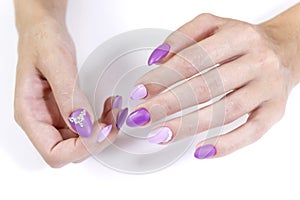 Hands of a client of a beauty salon with manicure gel varnish in two colors and rhinestones.