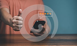 Hands of Client holding and giving a Five Star Rating feedback and raised thumbs up