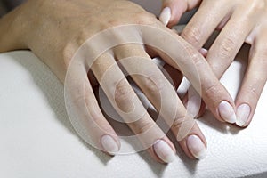 Hands of a client with manicure before applying a gel base close-up