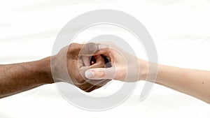 Hands close up multiracial couple african man and caucasian woman romantically touch each other handshake on white