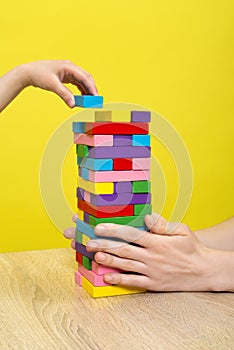 Hands close up playing a round of jenga or tower with wooden blocks. Planning, risk and strategy in business or building