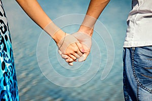 Hands closeup of a loving couple, romance, love, jeans. Concept idyll