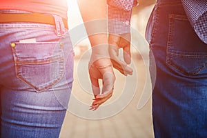 Hands closeup of a loving couple, romance, love, jeans. Concept idyll