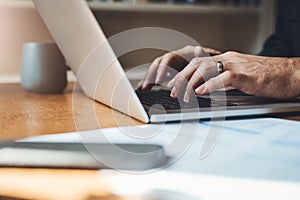 Hands, closeup and man with laptop in home office for finance, review or budget planning. Fingers, keyboard and male