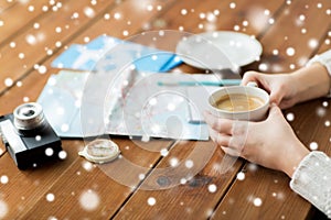 Hands with coffee cup and travel stuff