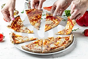 Hands of colleague or friends eating pizza, party at home, eating pizza and having fun. People Hands Taking Slices Of Pizza.