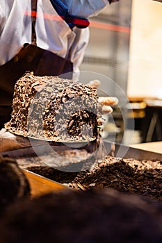 A hands of confectioner-chocolatier during at work. The making of cake