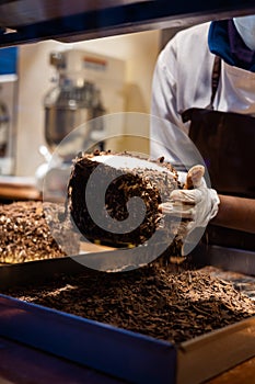 A hands of confectioner-chocolatier during at work. The making of cake