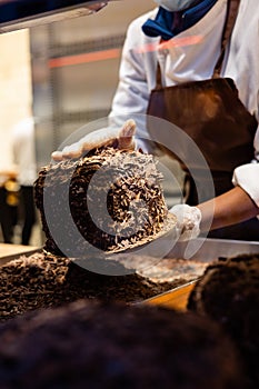 A hands of confectioner-chocolatier during at work. The making of cake