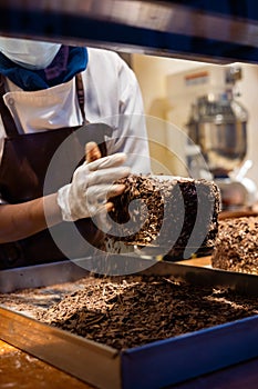 A hands of confectioner-chocolatier during at work. The making of cake