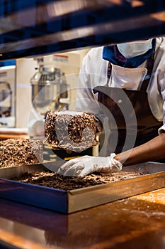 A hands of confectioner-chocolatier during at work. The making of cake