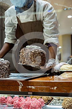 A hands of confectioner-chocolatier during at work. The making of cake The merveilleux (marvelous)
