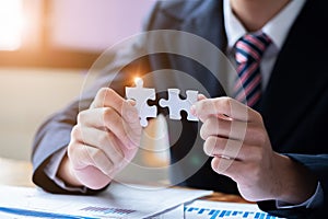 Hands connecting jigsaw puzzle. Business solutions, success and strategy concept. Close up photo with selective focus
