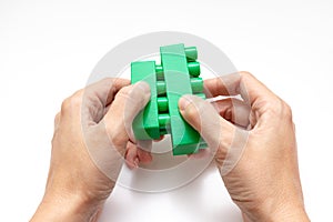 Hands constructing from colorful toy plastic bricks, blocks for building on white background