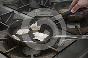 Hands cook, fry in a frying pan chicken